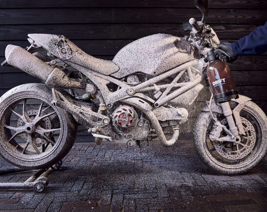 Ducati Monster die wordt ingespoten met een Snowfoam Motorshampoo.