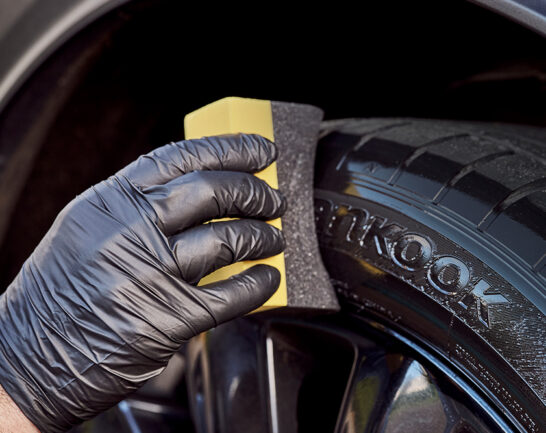 Hankook autoband die wordt behandeld met Bandenzwart in combinatie met een Bandenapplicator.